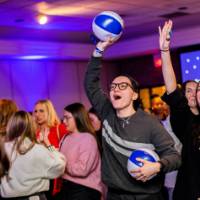 Grads cheer holding GVSU beach balls